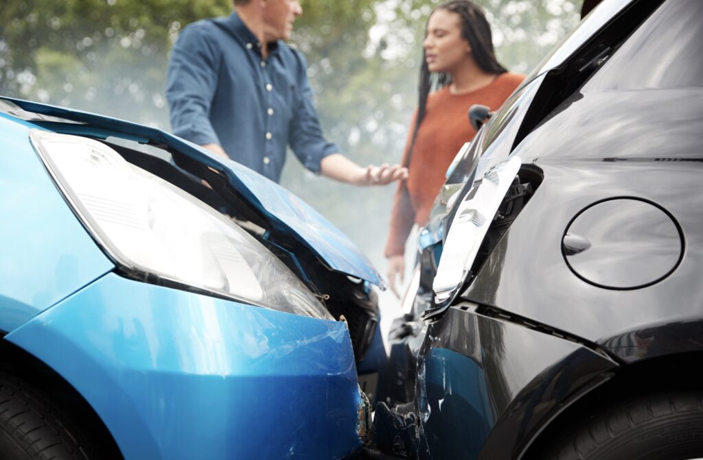 Twee auto's zijn gebotst. Twee mensen zijn aan het praten.